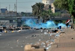 Iraqi security forces fire tear gas while anti-government protesters gather for a demonstration in Baghdad, Iraq, Oct. 4, 2019.