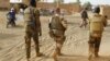 Des soldats de l'armée malienne patrouillent avec des soldats de la force française Barkhane dans une rue de Menaka dans la région de Liptako au Mali le 21 mars 2019.
