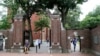 FILE - Para pejalan kaki melewati gerbang Harvard Yard di Universitas Harvard, Cambridge, Massachusetts.