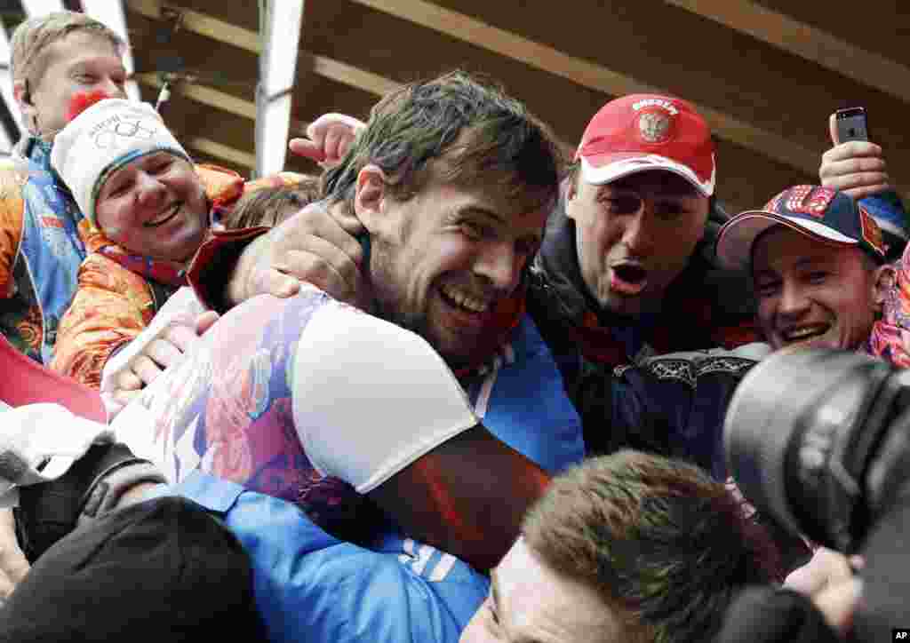 Alexander Tretiakov of Russia celebrates with fans and supporters in the finish area after he won the gold medal during the men's skeleton competition, Krasnaya Polyana, Russia, Feb. 15, 2014.