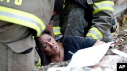A woman is pulled out from under tornado debris at the Plaza Towers School in Moore, Oklahoma, May 20, 2013. 