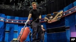 Un assistant de plateau passe l'aspirateur sur le plateau où va se dérouler mercredi 19 octobre le dernier débat entre Donald Trump et Hillary Clinton, à l'Université du Nevada, Las Vegas.