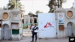 Christopher Stokes, second left, the general director of Doctors Without Borders stands at the gate of its hospital after U.S. troops left the area in Kunduz, Afghanistan, Oct. 15, 2015. 
