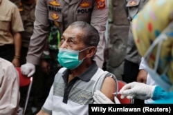 Inan Rustandi, 72 tahun, warga Desa Sindanglaya, bereaksi saat menerima dosis pertama vaksin Sinovac Biotech, Jawa Barat, 15 Juni 2021. (Foto: REUTERS/Willy Kurniawan)