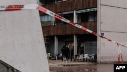 A police line blocks the way as officers stand guard in front of the Aksehir bar where a grenade was thrown the night before in the Grenoble Olympic Village, part of La Villeneuve district, in Grenoble, France, on Feb. 13, 2025. 