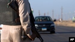 FILE - A policeman stands alert near the site of the Cathedral road in Minya, Egypt, May 26, 2017. Gunmen reportedly opened fire Friday on a bus carrying Christian pilgrims to a monastery in the area.