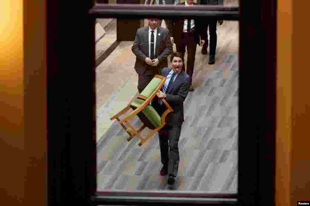 Perdana Menteri Kanada Justin Trudeau yang segera berakhir masa jabatannya, membawa kursinya dari House of Commons di Gedung Parlemen Kanada di Ottawa, Ontario. (Reuters)