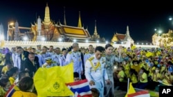 King Maha Vajiralongkorn, center left and Queen Suthida, center right wave to supporters in Bangkok, Thailand, Nov. 1, 2020.