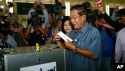 Cambodia's Prime Minister Hun Sen, center, casts his ballot at a polling station in Takhmau town, south of Phnom Penh, Cambodia, Sunday, July 28, 2013.