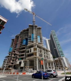 A high-rise building under construction is shown next to a high-rise condominium building, Sept. 7, 2017, in downtown Miami.