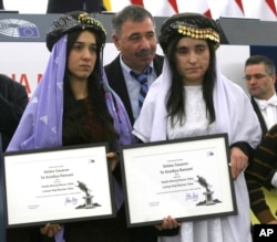 Yazidi women from Iraq, Nadia Murad, left, and Lamiya Aji Bashar, pose with their award after receiving the European Union's Sakharov Prize for human rights at the European Parliament in Strasbourg, France, Dec. 13, 2016.