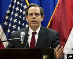 FILE - In this Oct. 1, 2015, photo, Stuart Jones speaks at a news conference at the U.S. Embassy in Baghdad, Iraq. The Trump administration is accusing the Syrian government of carrying out mass killings of thousands of prisoners and burning the dead bodi