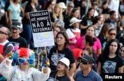 Demonstrators protest during a strike against Brazilian Social Welfare reform project, in Curitiba, Brazil, March 15, 2017. The placard reads: "Work until die? No to reform."