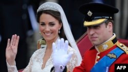 Britain's Prince William and his wife Kate, Duchess of Cambridge, wave as they travel in the 1902 State Landau carriage along the Processional Route to Buckingham Palace, in London, April 29, 2011.