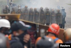 FILE - Venezuelan National Guard members take position while clashing with demonstrators rallying against Venezuela's President Nicolas Maduro in Caracas, Venezuela, June 6, 2017.