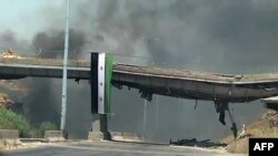 An image grab taken from a video released by the United Nations Supervision Mission in Syria shows smoke rising following shelling from the central flashpoint city of Homs on June 11, 2012. 