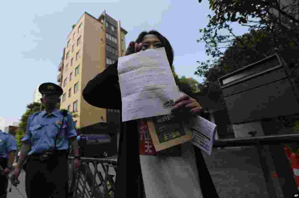 Seorang demonstran menunjukkan surat protes sebelum memasukkannya ke dalam kotak surat di Kantor Kedutaan Besar China di Tokyo, Jepang (4/6).