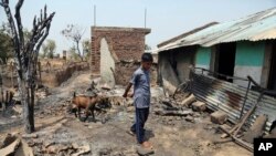 An Indian boy leads a goat past a house damaged in cross border firing, during a lull in shelling between India and Pakistan in Jora farm village, in Ranbir Singh Pura district, India, May 30, 2018. 