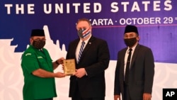 Menlu AS Mike Pompeo (tengah) menerima plakat dari Ketua Umum GP Ansor Yaqut Cholil Qoumas, didampingi Sekjen PBNU Yahya Cholil Staquf (kanan), di Jakarta Kamis (29/10).