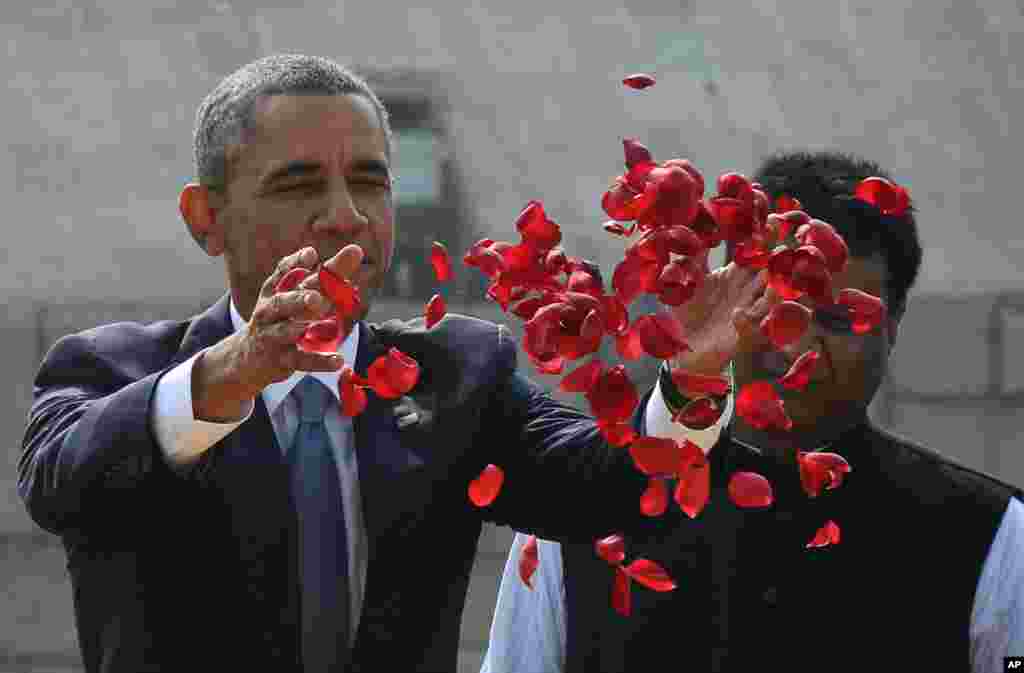 Presiden Barack Obama menebarkan bunga di lokasi kremasi Mahatma Gandhi di New Delhi (25/1).