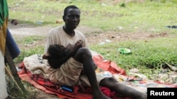 Penderita Ebola, James Flomo menggendong anaknya di Monrovia, Liberia, setelah istri James meninggal akibat ebola tiga hari sebelumnya (foto: dok).