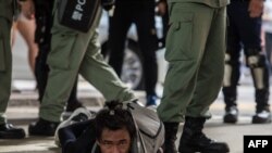 Polisi wa kuzuia ghasia wakimshikilia mmoja wa waandamanaji wakati wakiwatawanya walipokuwa wakipinga sheria mpya ya usalama wa taifa mjini Hong Kong on Julai 1, 2020, katika maadhimisho ya miaka 23 ya Hong Kong kukabidhiwa China kutoka utawala wa Uingereza.