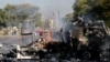 Un habitant passe devant un camion incendié près de la route où les manifestants sont passés à Atteridgeville, à l'ouest de Pretoria, Afrique du Sud, le 21 juin 2016.
