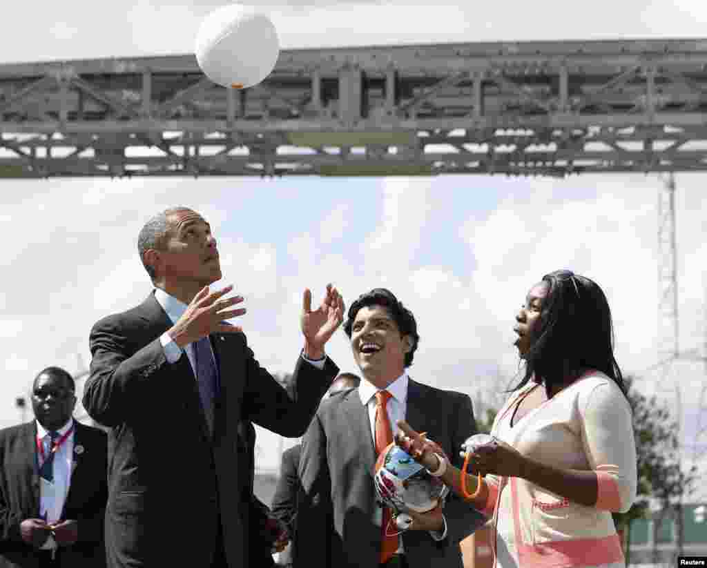 U.S. President Barack Obama heads a soccer ball at Ubungo Power Plant in Dar es Salaam, July 2, 2013. The ball called a "soccket ball" has internal electronics that allows it to generate and store electricity that can power small devices.