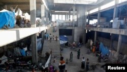 FILE - Displaced people are seen inside a building under construction at the Shire campus of Aksum University, which was turned into a temporary shelter for people displaced by conflict, in the town of Shire, Tigray region, Ethiopia, March 14, 2021. 