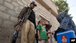 Un membre du personnel de santé pakistanais fait le porte-à-porte pour vacciner les enfants contre la polio à Karachi, au Pakistan, le 15 février 2016.