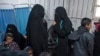 ARSIP - Dua wanita (tengah), diduga para istri dari petempur kelompok Islamic State (IS), menunggu bersama para wanita dan anak-anak lainnya dalam sebuah klinik darurat di kamp Internally Displaced Person (IDP) di provinsi al-Hol Hasakeh, timurlaut Suriah, 7 Februari 2019 (foto: 