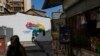 Locals walk past a mural of the Venezuelan map with the Essequibo territory included, in Caracas, Venezuela, on November 29, 2023. (Matias Delacroix/AP)
