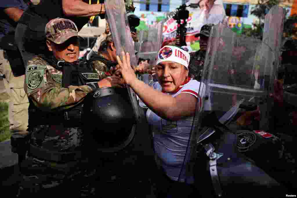Seorang demonstran bentrok dengan pasukan keamanan saat para pendukung mantan Presiden Peru Pedro Castillo berunjuk rasa di luar pusat penjara tempat dia ditahan di ibu kota Lima. (Reuters)
