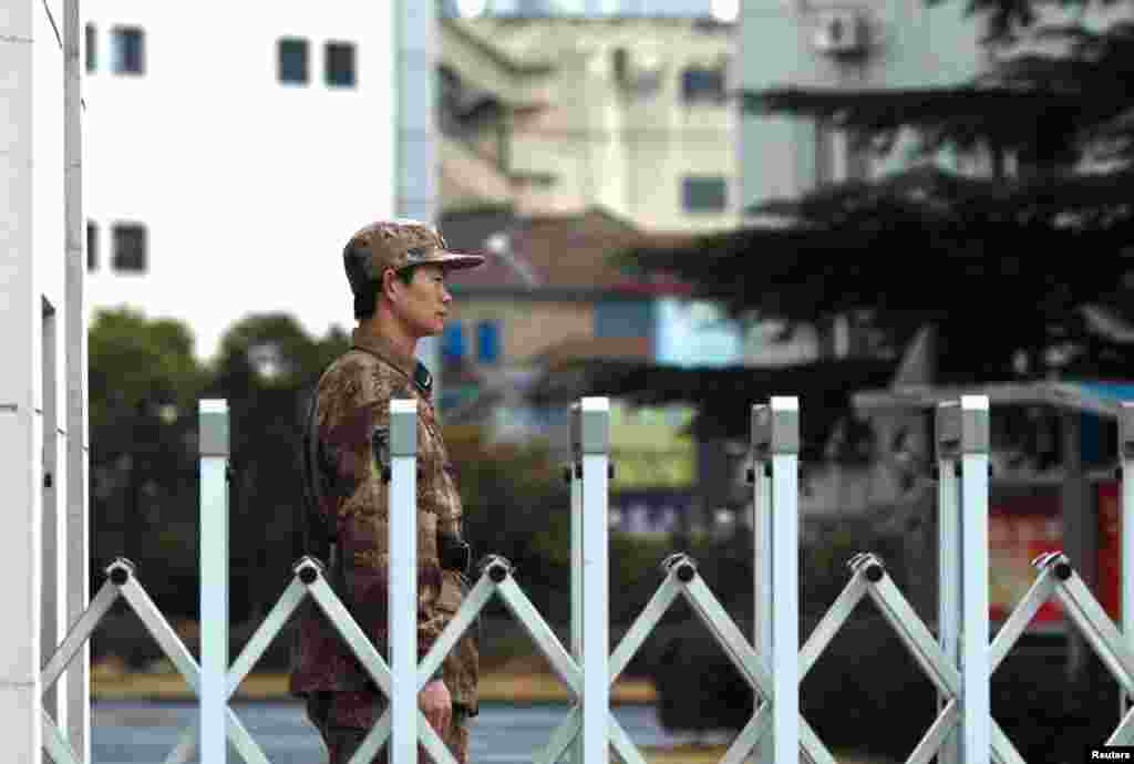 A Chinese People's Liberation Army soldier stands guard in front of Unit 61398 in Shanghai. The Mandiant report says Chinese hackers have focused on stealing information like technology blueprints, manufacturing processes and other information from foreign companies.