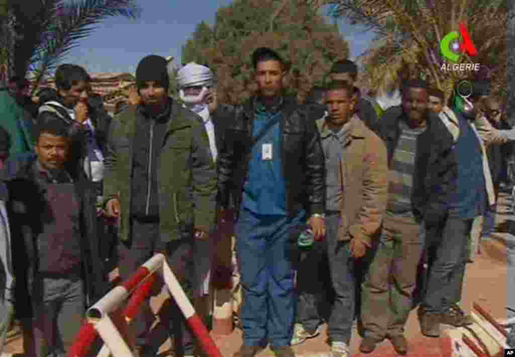 Unidentified former hostages pose for the media in Ain Amenas, Algeria, in this image taken from television , January 18, 2013. (Canal Algerie)