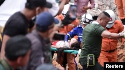 Tim penyelamat mengevakuasi seorang pekerja yang terluka di sebuah gedung yang runtuh di Sihanoukville, Kamboja, 22 Juni 2019. 