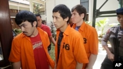 Suspected Islamic militants, from left to right, Abdulbasit Tuzer, Ahmet Mahmud and Abdullah are escorted by police officers prior to their trial hearing at North Jakarta District Court in Jakarta, Indonesia, Monday, July 13, 2015.
