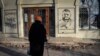 Seorang warga tampak mengamati grafiti yang menampilkan wajah Panglima Militer Ukraina Valery Zaluzhny di salah satu sudut di Kota Bakhmut, pada 20 Desember 2023. (Foto: AP/Andriy Andriyenko)