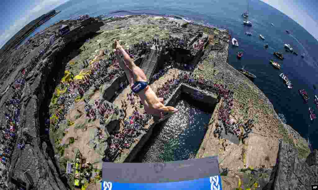 In this handout photo made available by Red Bull, David Colturi of the USA dives from the 28-meter platform at the Serpent's Lair during the third stop of the Red Bull Cliff Diving World Series at Inis Mor, Aran Islands, Ireland, June 29, 2014