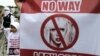 A child stands next to an anti-Lady Gaga banner in Jakarta April 29, 2012.