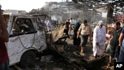 Warga melongok lokasi serangan bom di pasar Jameela di Sadr City di Baghdad, Irak, Kamis (13/8).