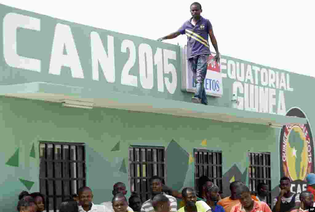 Un homme passe devant les écrits annonçant l'ouverture du tournoi de la Coupe d'Afrique des Nations de football à Bata, en Guinée équatoriale, le vendredi 16 janvier 2015.