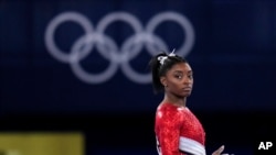 Simone Biles, of the United States, lands from the vault during the artistic gymnastics women's final at the 2020 Summer Olympics, July 27, 2021, in Tokyo.