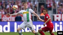 L’attaquant Rafinha de Munich, à droite, et André Hahn de Gladbach se battent pour récupérer un ballon lors du match de football de la Bundesliga entre le Bayern Munich et le Borussia Moenchengladbach au stade Allian, à Munich, Allemagne, 30 avril 2016.