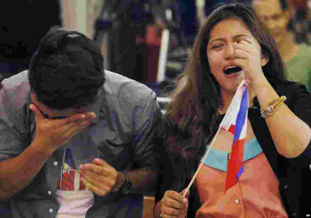 Filipinos react to the Hague-based U.N. international arbitration tribunal's ruling favoring the Philippines in its case against China on the South China Sea dispute, in Manila, Philippines. The international tribunal has found that there is no legal basis for China's "nine-dash line" claiming rights to much of the South China Sea.