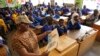 FILE - Helen Mashele from South Africa reads the biography of former South African president Nelson Mandela to pupils at Kilimani Primary School in Kenya's capital Nairobi, July 18, 2013.