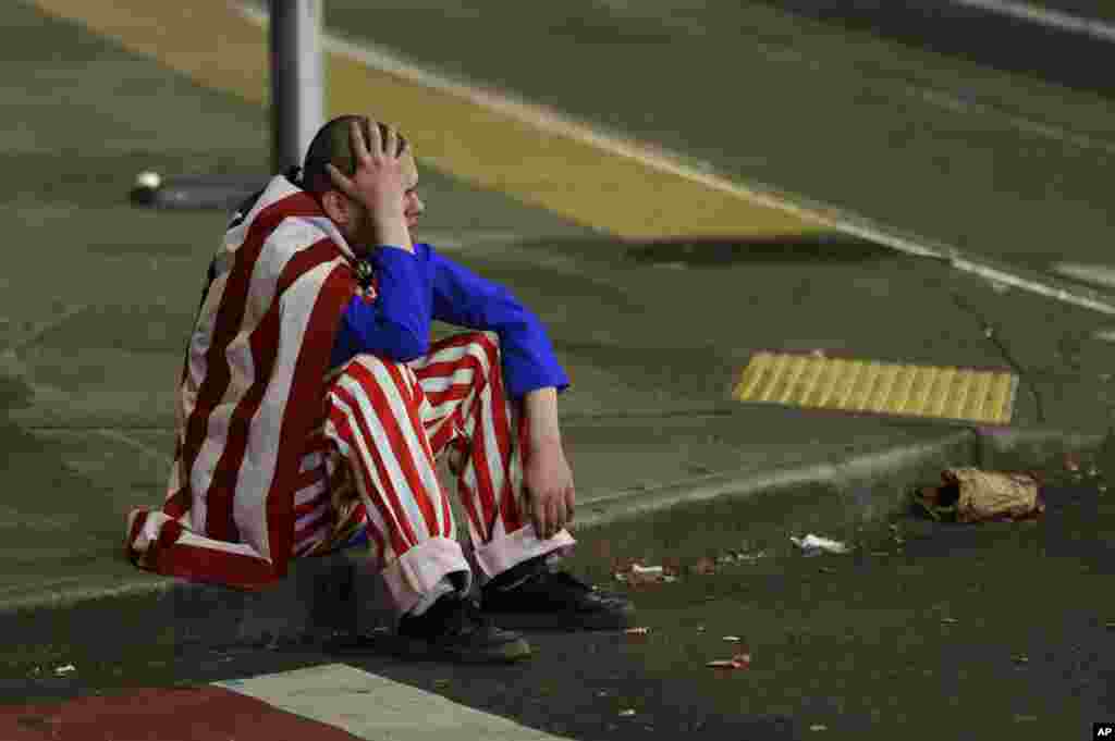 A man dressed in red-white-and-blue sits on the curb during a protest against President-elect Donald Trump, Nov. 9, 2016, in Seattle's Capitol Hill neighborhood.