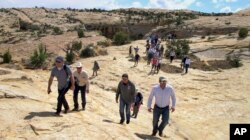Utah state legislators and their staff lead the way for Interior Secretary Ryan Zinke, Utah Gov. Gary Herbert and others in the distance, May 8, 2017, through Bears Ears National Monument near Blanding, Utah.
