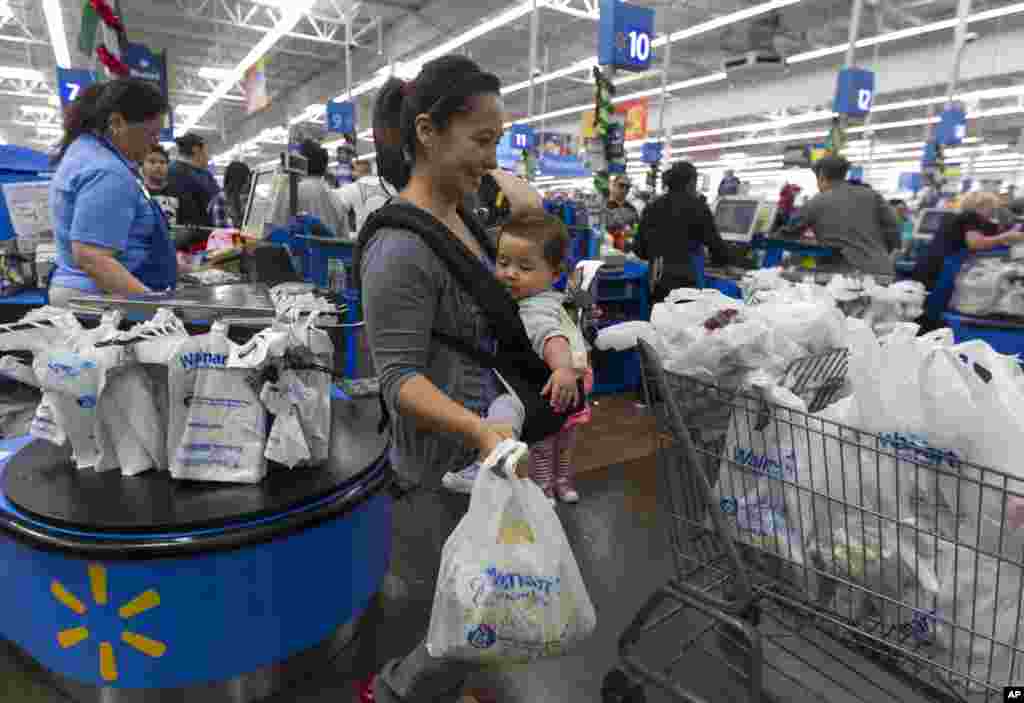 Eva Cevallos with her eleven-month daughter, Quinn, shops for Thanksgiving at the Pre-Black Friday event at the Walmart Supercenter store in Rosemead, California, November 21, 2012.