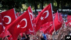 Para pengunjuk rasa pro-pemerintah melambaikan bendera Turki seraya berunjuk rasa terhadap usaha kudeta (19/6). Istanbul, Turki. (foto: AP Photo/Lefteris Pitarakis)